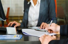 A borrower is meeting with a lender and signing documents