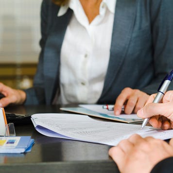 A borrower is meeting with a lender and signing documents