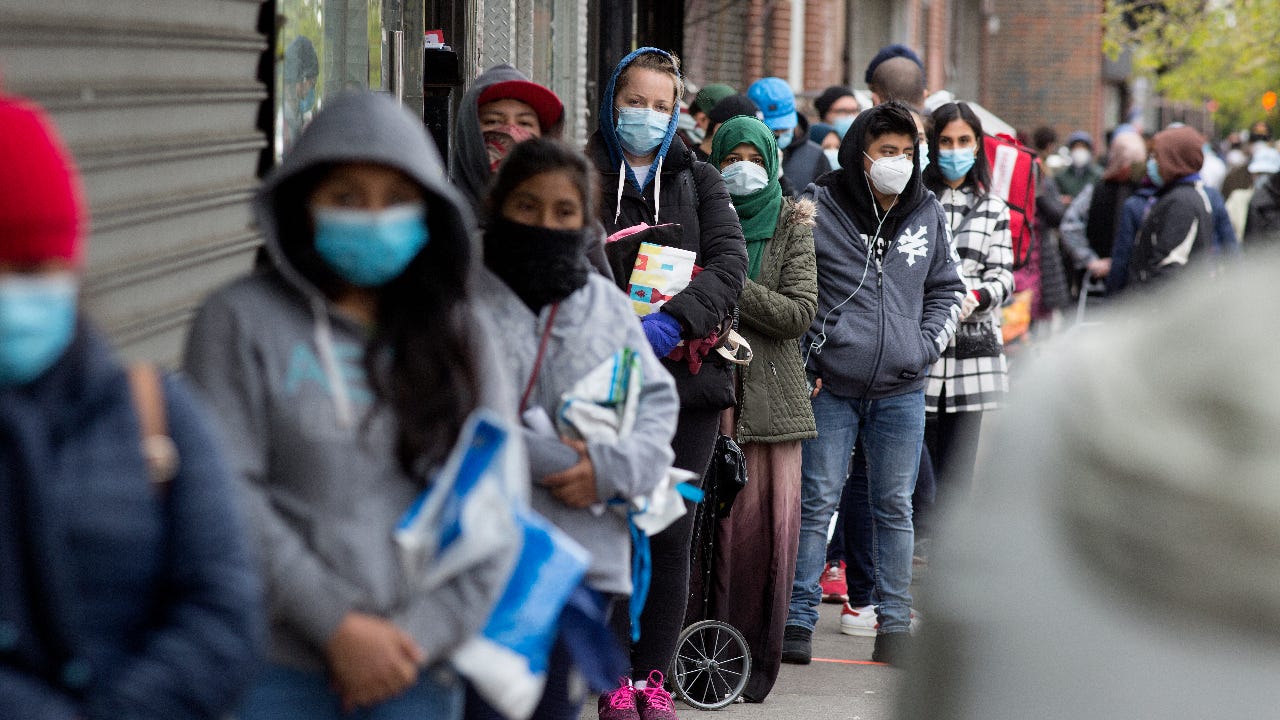 Citizens wearing protective masks form lines to receive free food from a food pantry in Brooklyn, New York