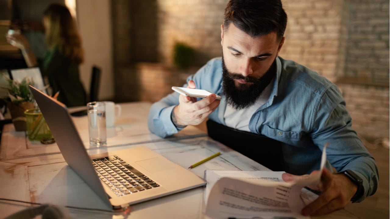 Worried man looking through paperwork.