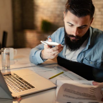 Worried man looking through paperwork.