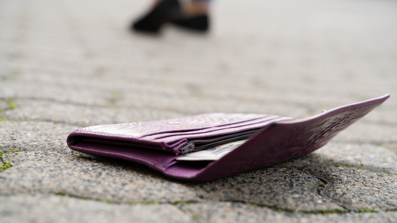 woman walking away from wallet on ground