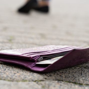 woman walking away from wallet on ground