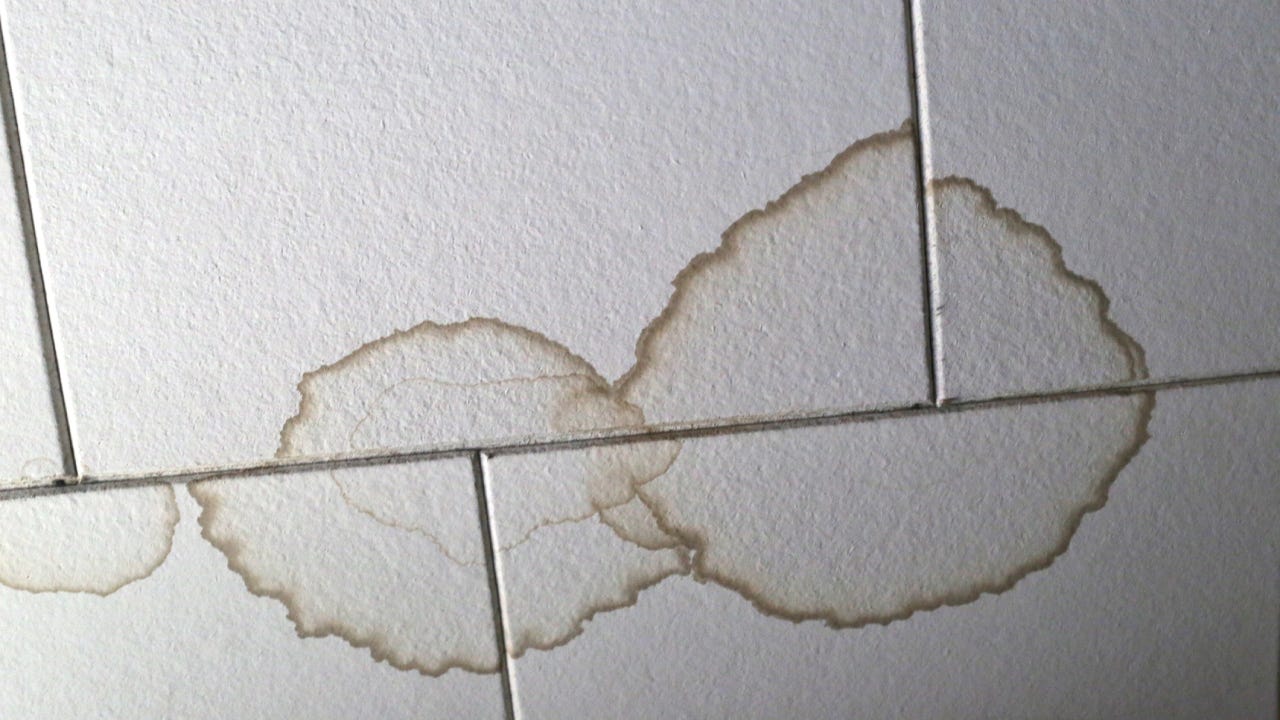 A ceiling with water damage stains