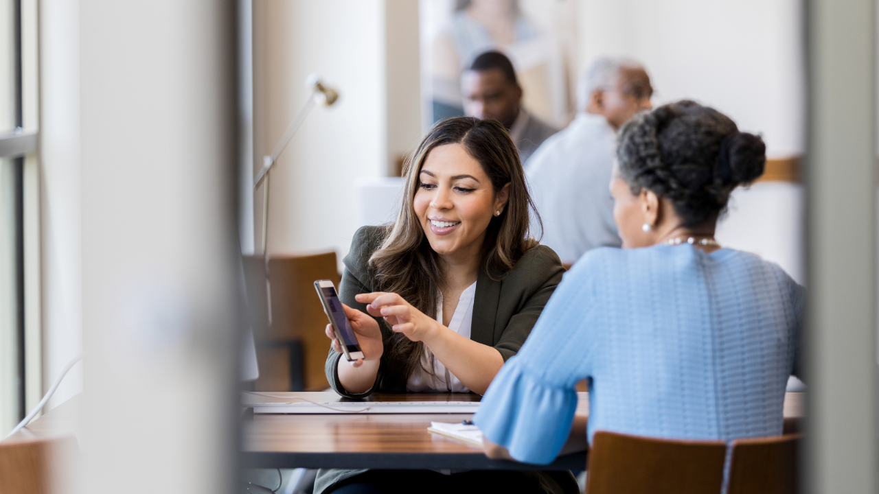 Woman sitting at a table using her smart phone