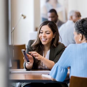 Woman sitting at a table using her smart phone