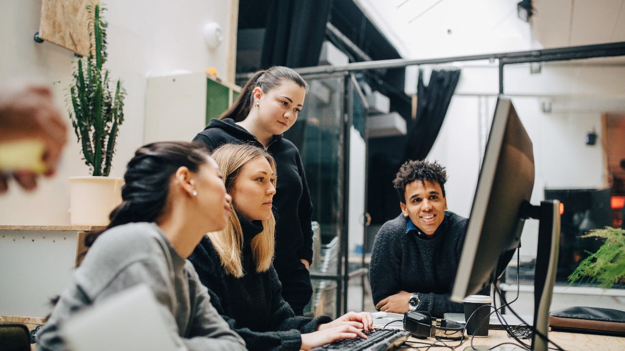 A group of colleague discuss over a computer