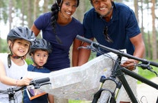 Family with bicycles and map