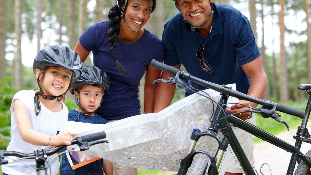 Family with bicycles and map