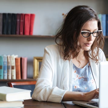 Woman looks over finances on computer.