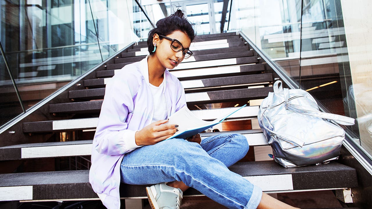 College student sits on steps while studying.