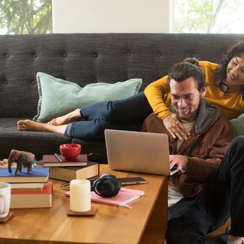 A young couple relaxes and laughs on their couch