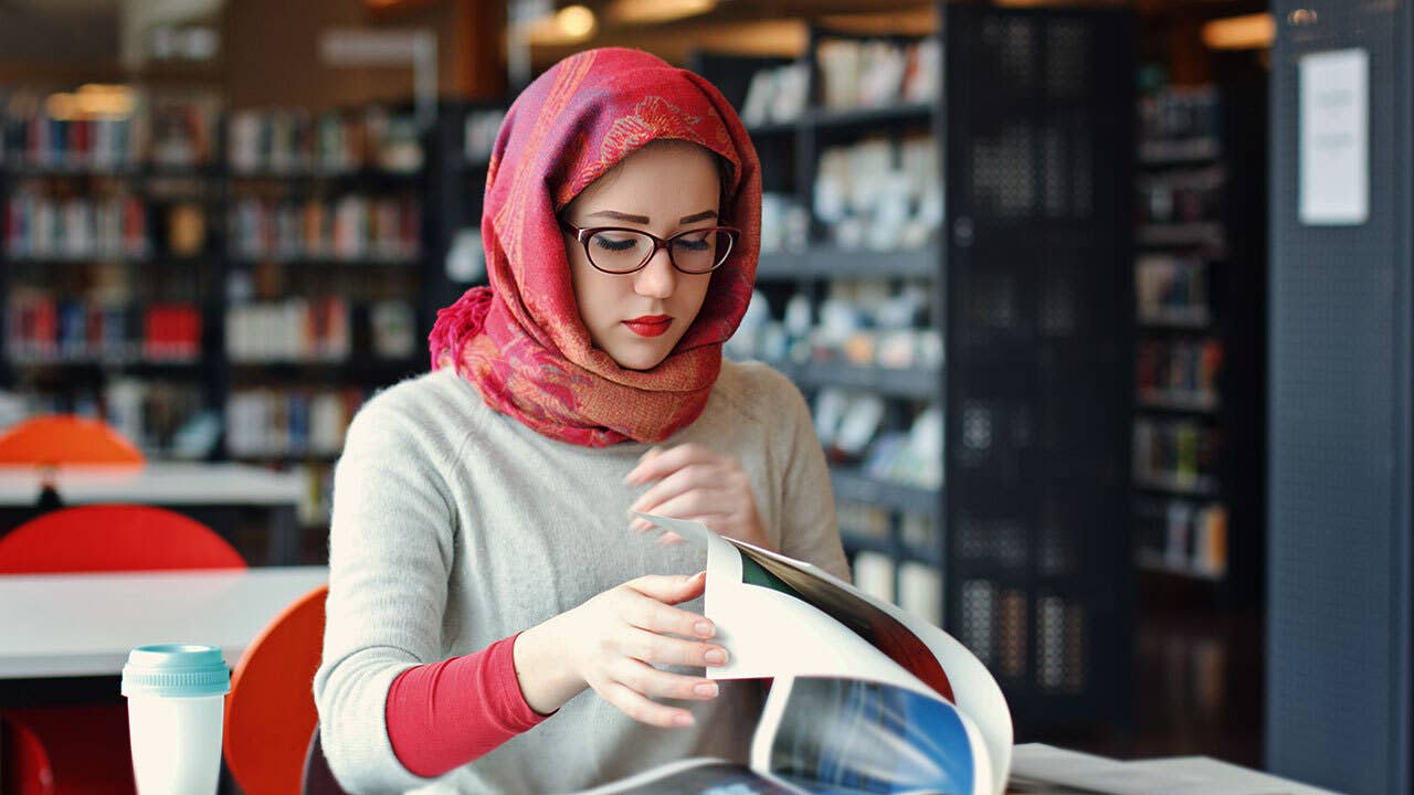 Woman studies in college library.