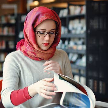 Woman studies in college library.