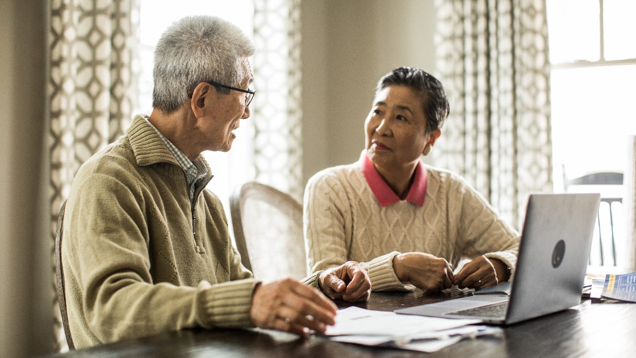 An older Asian couple seated at a table