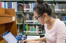 College student studies in library.