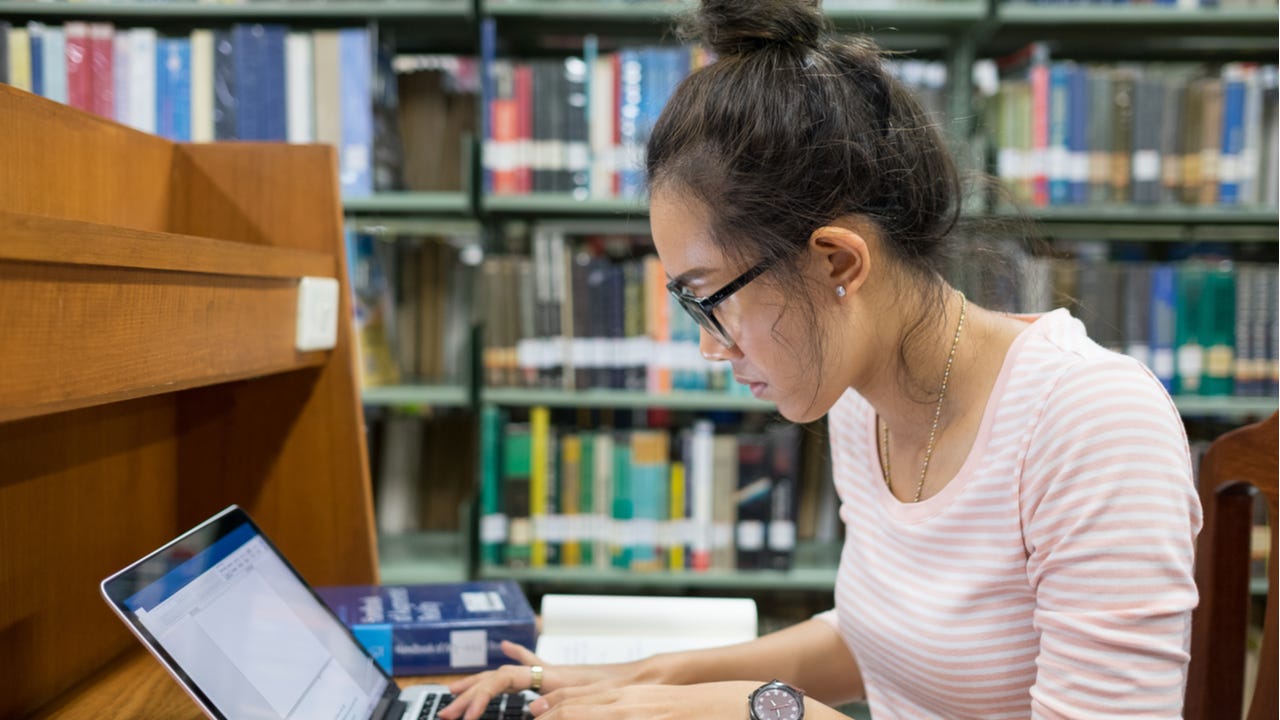 College student studies in library.