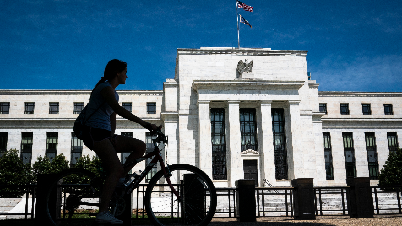 A bicyclist rides past the Federal Reserve Eccles building in Washington, D.C.