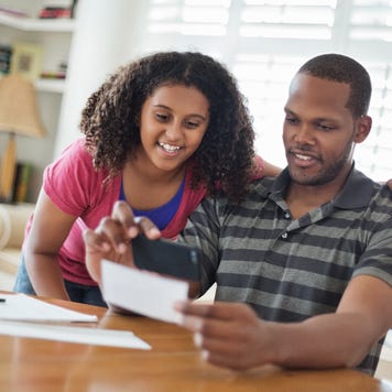 Daughter and father using mobile phone
