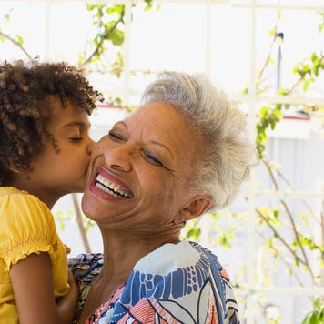 A young Black girls kisses her older Black relative