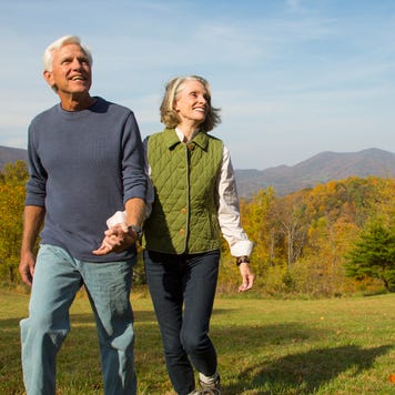 An older couple walks in a field