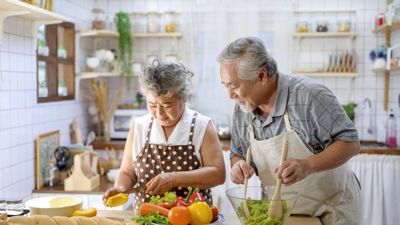 An older couple spends some time together cooking and preparing dinner.