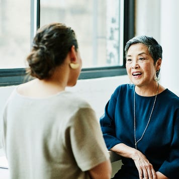 An older Asian businessowoman discusses something