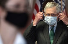 Senate Majority Leader Mitch McConnell puts on a mask