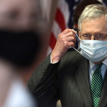Senate Majority Leader Mitch McConnell puts on a mask