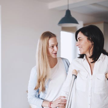 Daughter helps mother adjust to her new crutches.