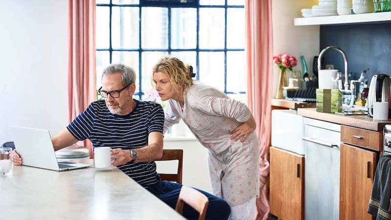 Mature couple at home using laptop to plan home finances