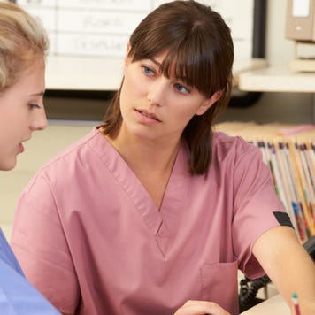 Two nurses work on paperwork