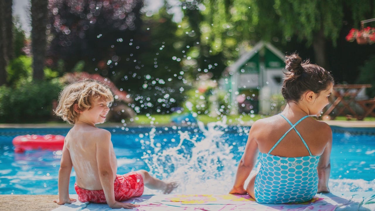 Two children splash by the pool.