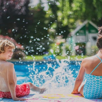 Two children splash by the pool.