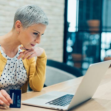 Person looking at laptop with credit card