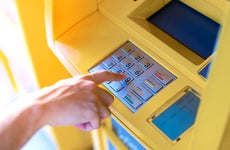 Man hand entering his PIN at an ATM