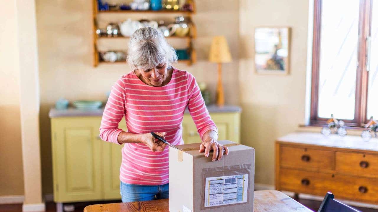 Senior woman unpacking a package from an online purchase