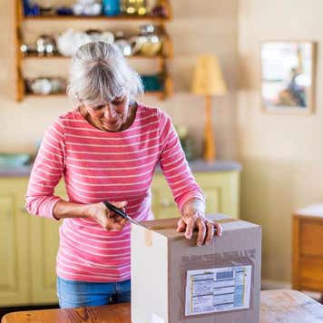 Senior woman unpacking a package from an online purchase