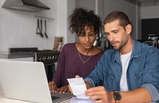 Young couple work on finances at kitchen table