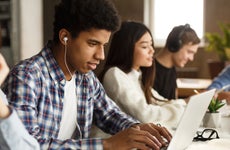 High school students study on laptops