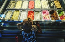 A young girl looks at a selection of ice cream