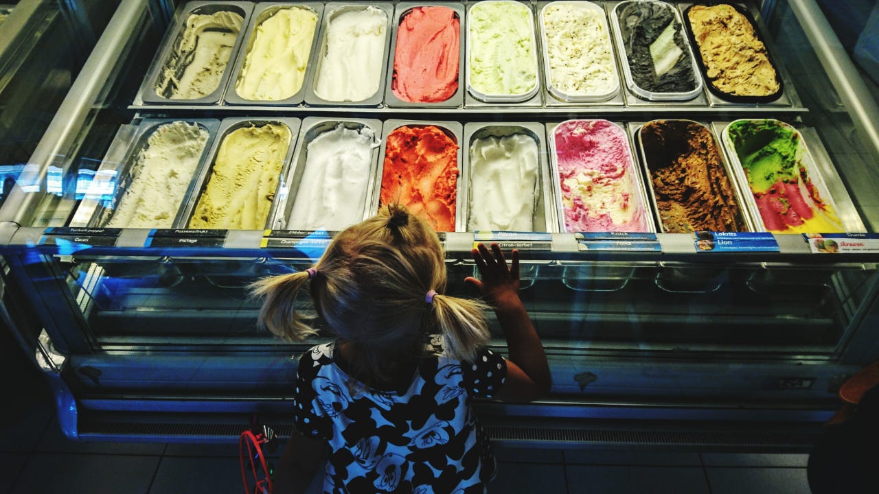 A young girl looks at a selection of ice cream