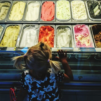A young girl looks at a selection of ice cream
