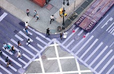 A picture from above of pedestrians crossing a busy street