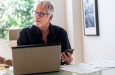 Senior man sitting in home office and using laptop