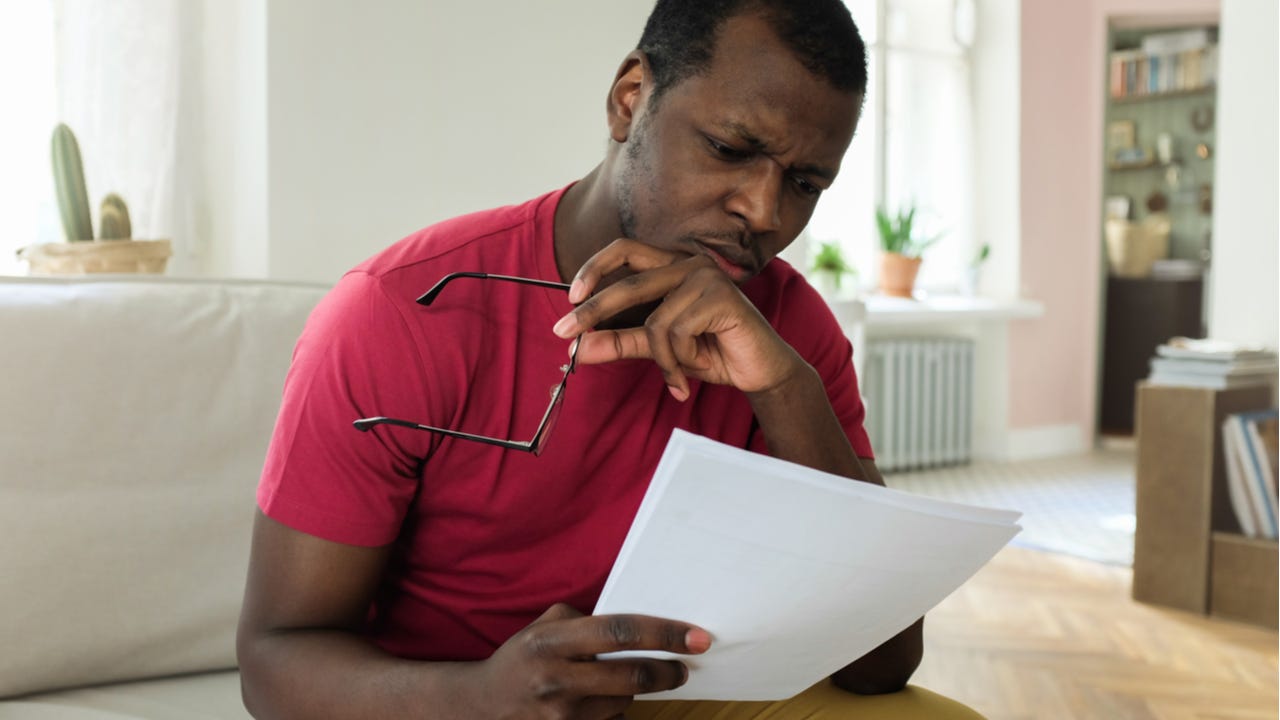 Man looks puzzled at item on credit card statement