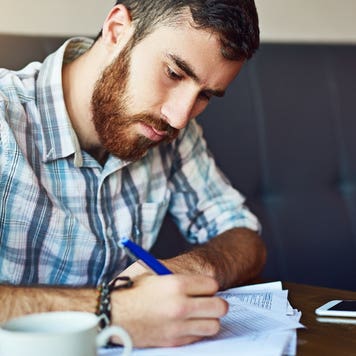 Man signs paperwork in a coffee shop