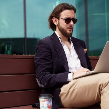 Man works on laptop outside