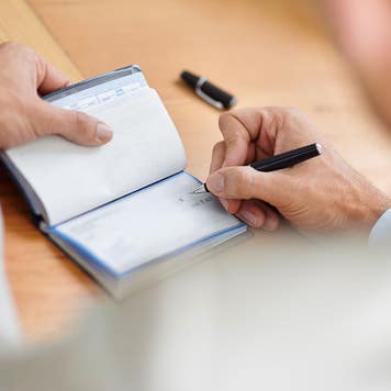 man signing a check
