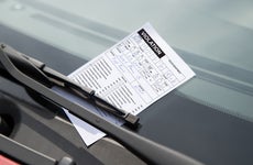 Shot of a parking ticket secured to a windshield by a wiper.